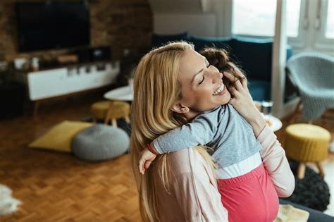 Premium Photo Loving Mother With Eyes Closed Embracing Her Daughter At Home