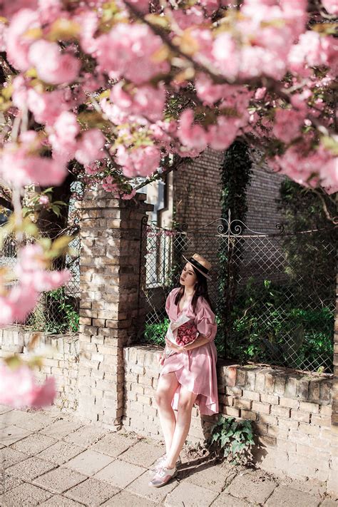 Young Woman Walking Under Sakura Tree By Stocksy Contributor Jovana