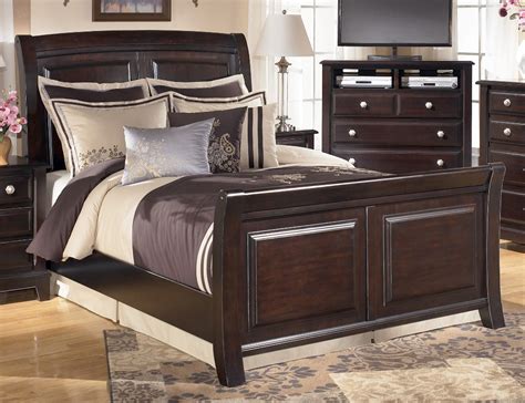 Many of our beds come in rich pine and cherry finishes, which give an added feeling of warmth and comfort. Ridgley Queen Sleigh Bed from Ashley (B520-77-74-98) | Coleman Furniture