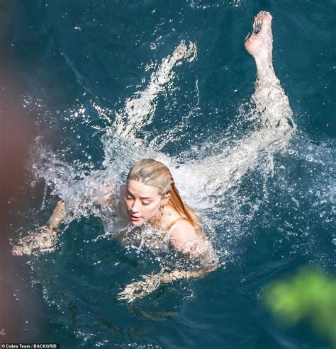 Amber Heard Highlights Her Sensational Physique In A White High Leg Swimsuit During Sun Soaked
