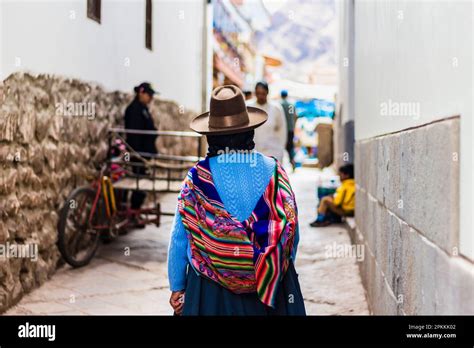 Woman Walking Away In Narrow Street With Traditional Colorful Peruvian