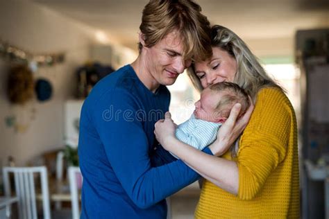 Beautiful Young Parents With A Newborn Baby At Home Stock Photo