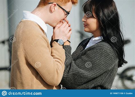 Caring Young Man Warming His Girlfriends Hands Holding In Palms