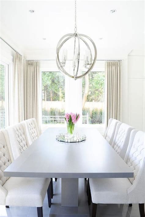 For a traditional look and feel, a dining room table with a long, rectangular shape accommodates multiple dinner guests at one time without feeling overcrowded. Gray Pedestal Dining Table with White Tufted Dining Chairs ...