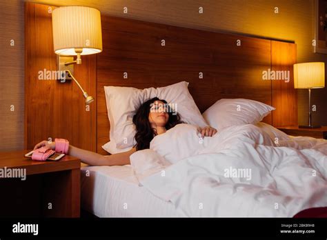 Pretty Girl Is Sleeping In Bed With Her Hand Tied To Her Smartphone With Pink Handcuffs She May