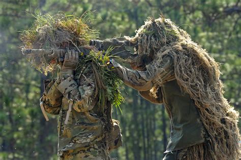 Two Snipers Wearing Ghillie Suits Combine To Form An Over The Shoulder