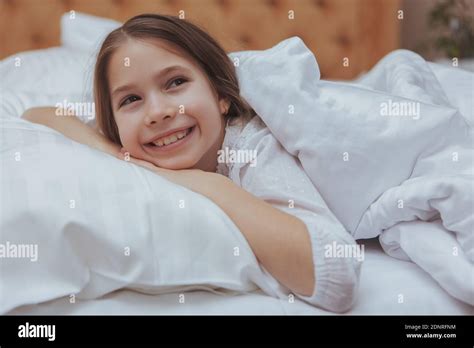 Little Beautiful Happy Girl Enjoying Lying In Her Bed Smiling Looking