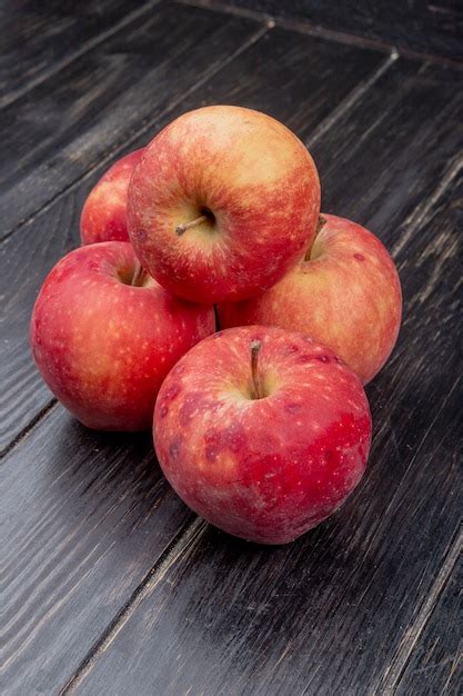 Vista lateral de maçãs vermelhas na madeira Foto Grátis