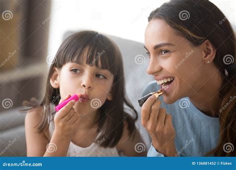 Hija Feliz De La Mamá Y Del Niño Que Se Divierte Que Hace El Maquillaje