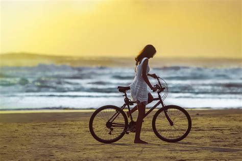 Download Lovely Girl On Beach Riding Bicycle Wallpaper