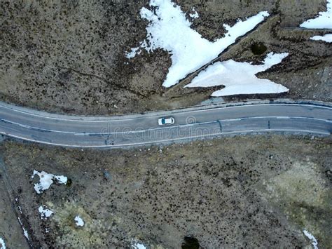 Aerial Aerial View Of A Mountain Road With Snowy Parts With A Car In