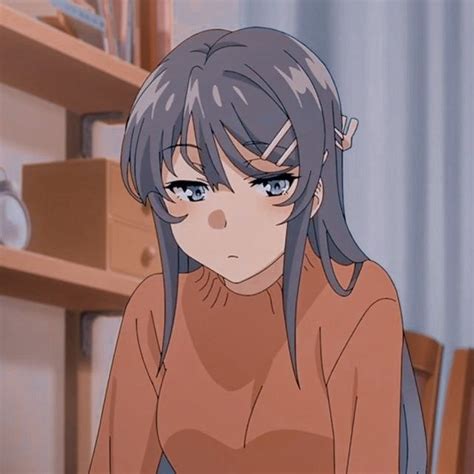 an anime character sitting in front of a book shelf