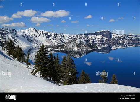 Mountains And Blue Sky Reflected In Water Of Crater Lake At Crater Lake
