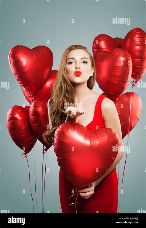 perfect woman blowing kiss pretty girl with red lips makeup and red heart balloons fashion