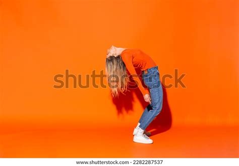 Woman Bending Over Backwards Against Orange Stock Photo 2282287537