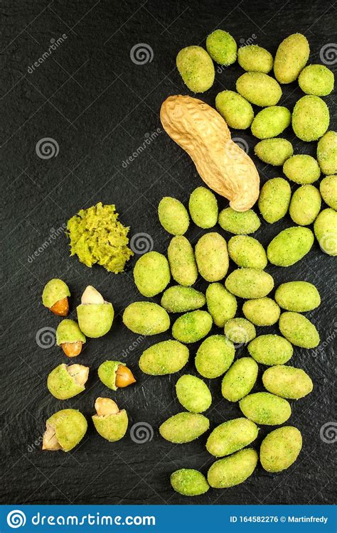 Wasabi Coated Peanuts On Slate Board. Japanese Wasabi Spice. Green Wasabi Peanuts On A Black 