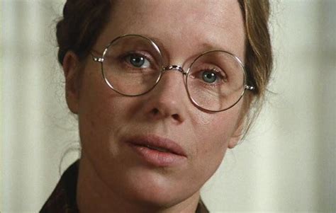A Woman Wearing Glasses Looking At The Camera With A Serious Look On Her Face