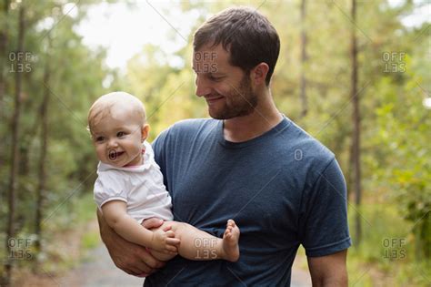 Happy Mid Adult Man Carrying Baby Daughter On Forest Track Stock Photo