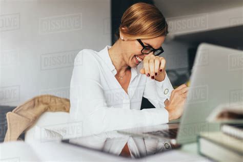 Business Woman In Spectacles Sitting At Her Desk In Office And Laughing Woman Sitting In Office