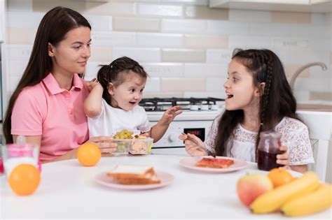 Madre Desayunando Con Hijas Foto Gratis