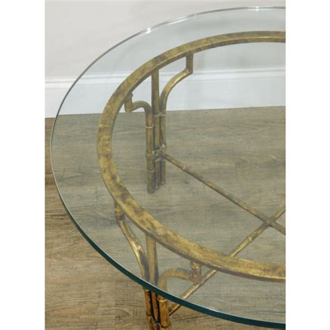 Stacked glass panels float within a plated metal frame, offering display storage in a smoky finish. Faux Bamboo Gilt Metal Base Round Glass Top Coffee Table ...