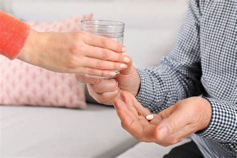 woman giving glass of water to senior man with pill indoors stock image image of giving