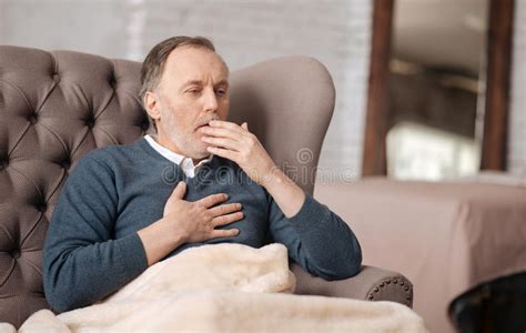 Old Man Sitting On Couch And Coughing Stock Photo Image Of Discomfort