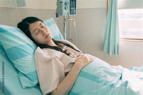 happy asian female patient lying on bed in hospital room sick beautiful japanese woman sleeping