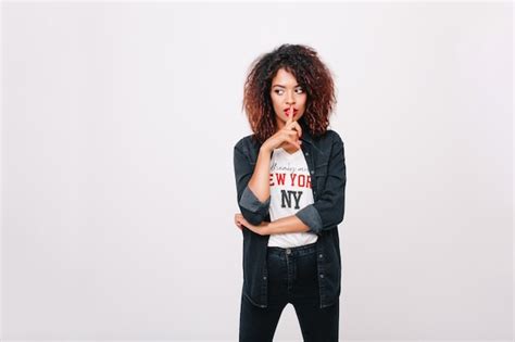 Free Photo Pensive Mulatto Girl With Brown Curly Hair Looking Away Touching Lips With Finger