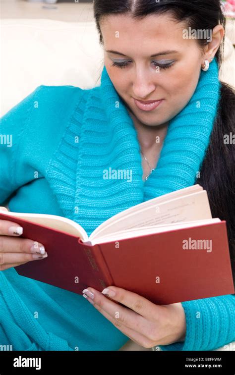 Young Woman Sitting On The Sofa Reading A Book Stock Photo Alamy