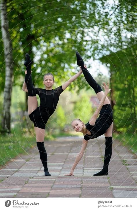 Two Teen Rhythmic Gymnasts Are Showing Their Stretching And Flexibility