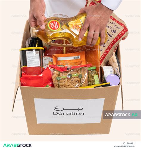 A Close Up Of A Saudi Arabian Gulf Man Packing A Food Box Donating To The Food Basket Project
