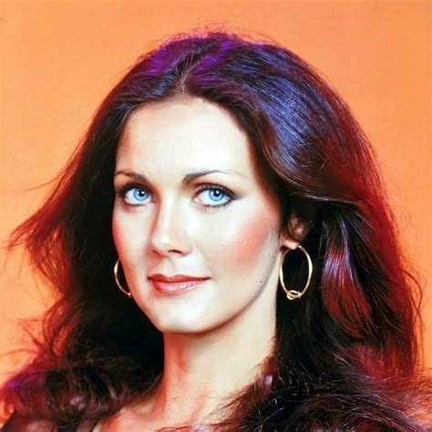 A Woman With Blue Eyes And Long Hair Wearing Large Gold Hoop Earrings