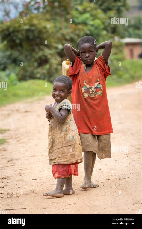 Two African Children On A Sandy Track Laughing Near Lake Mutanda