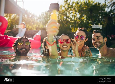 Group Of Happy Young People Enjoying Summer In Swimming Pool And Taking Selfie Friends Taking