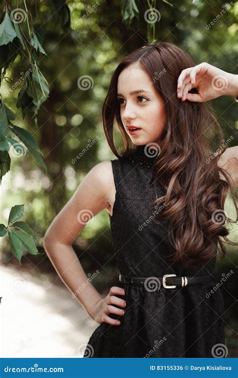 belle jeune fille dans la robe noire avec les longs cheveux a mignon superbe photo stock
