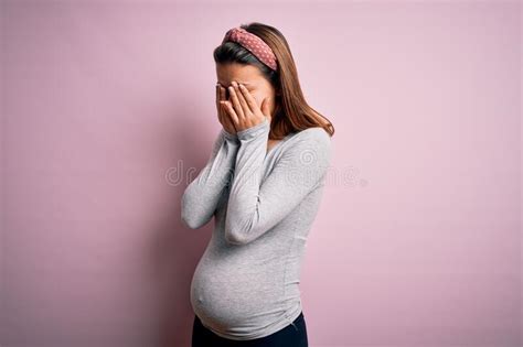 Mujer Embarazada Somnolienta Vestida De Rosa Con Un Fondo Azul Foto De Archivo Imagen De