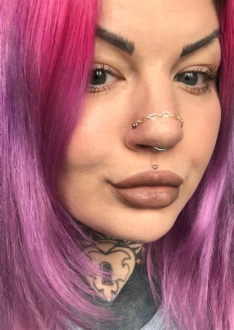 A Woman With Pink Hair And Piercings On Her Nose