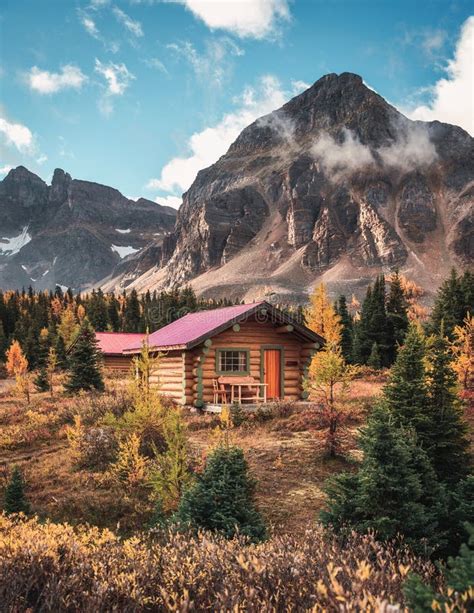 Wooden Hut With Rocky Mountains In Autumn Forest On National Park Stock