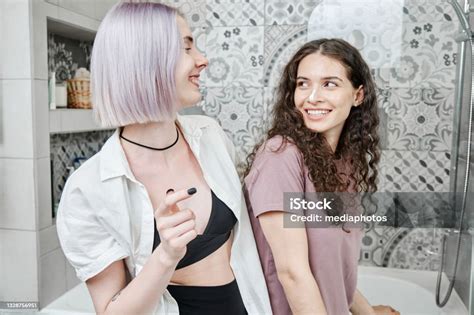 Happy Young Caucasian Lesbians In Homewear Laughing While Enjoying