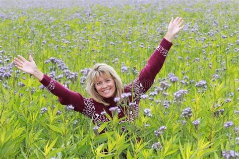 Happy Mature Woman In Front Of A Flower Field Stock Photo Image Of