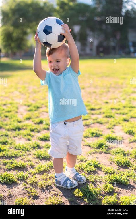 Little Kid Playing Football In A Stadium On A Sunny Day Stock Photo Alamy