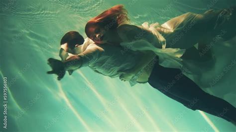 happy fantasy couple fall in love swim dive man king and woman fashion model posing underwater