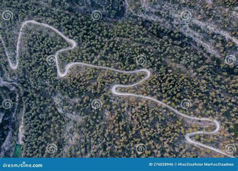 Aerial Shot Of A Curvy Road On A Mountain In A Forest Stock Photo