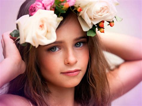 jolie fille a des fleurs couronne sur la tête face d un côté sur un fond rose 4k mignon hd