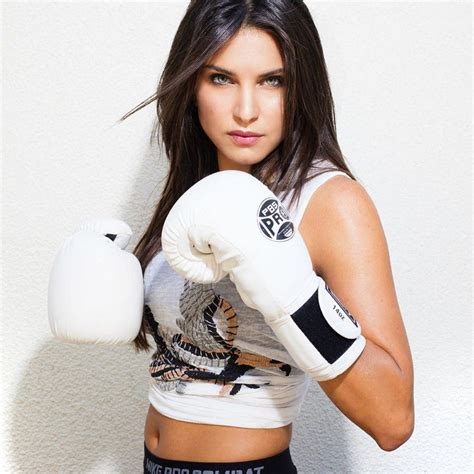 A Woman Wearing White Boxing Gloves Posing For A Photo With Her Hands