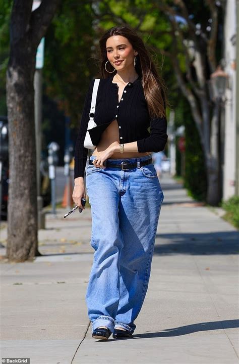 Madison Beer Flashes Her Very Toned Midriff In Low Rise Denim Jeans And A Black Cardigan As She