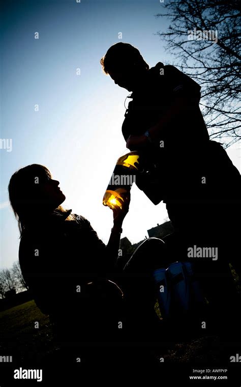 Teenager Drinking Bottle Of Alcohol In A Park Police Officer
