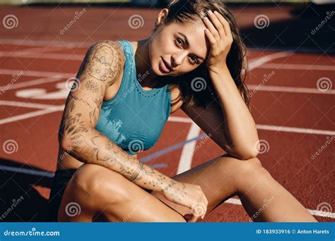 Beautiful Wet Athlete Girl With Tattooed Hand In Sportswear Thoughtfully Resting After Running