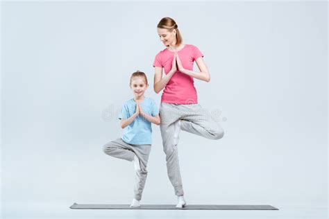 Smiling Sporty Mother And Daughter Practicing Yoga Together